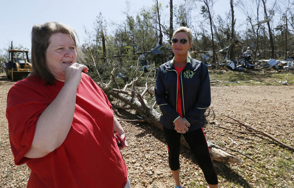 Standing amid debris, chicken farmer Cindy Wilkes recalls for her friend Tosha McLemore, how she and her family rode out Monday's tornado that destroyed their Noxapater, Miss., home and flattened their neighboring 8-chicken house farm operation Wednesday, April 30, 2014. The farm raises broilers for Tyson and each house has 28,500 chickens. Several poultry raising farms near Louisville, were either destroyed or damaged by the storms. (AP Photo/Rogelio V. Solis)