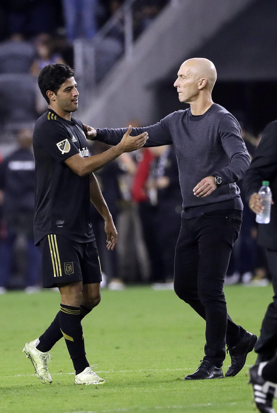 Los Angeles FC's Carlos Vela, left, is hugged by coach Bob Bradley after the team's 3-2 loss to Real Salt Lake during an MLS soccer playoff match Thursday, Nov. 1, 2018, in Los Angeles. (AP Photo/Marcio Jose Sanchez)