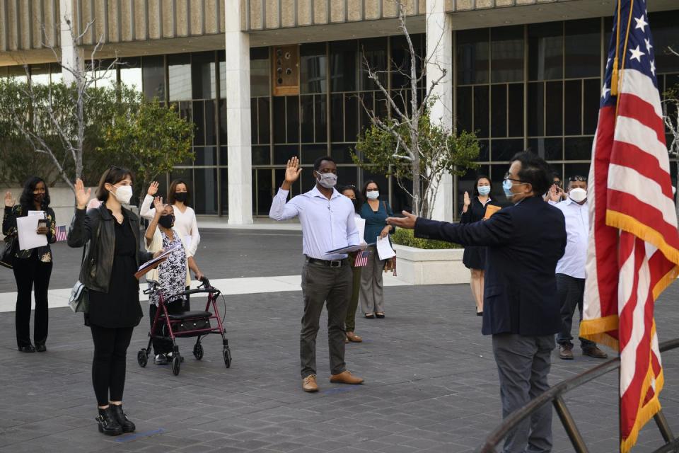 Immigrants hold up their hands.