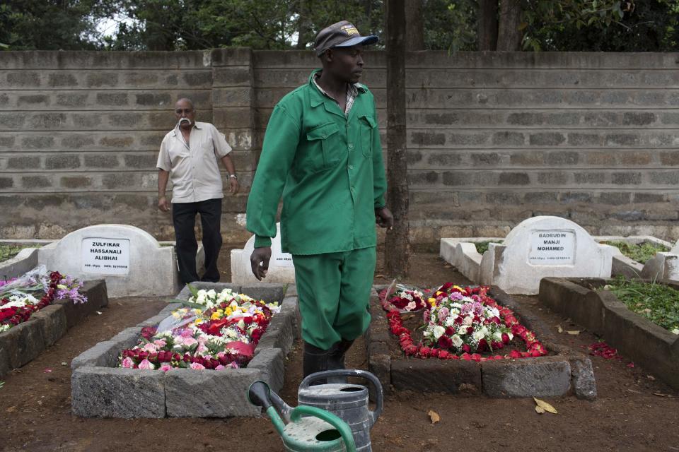 A cemetery worker walks between fresh graves of Westgate Shopping Centre shooting victims in Nairobi