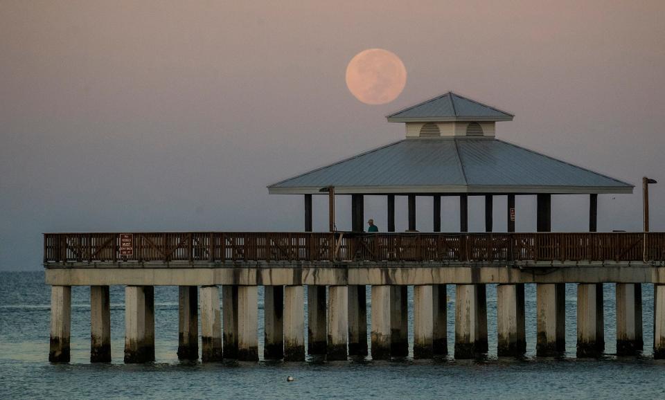 The full moon sets over the Fort Myers Beach pier recenty/ 