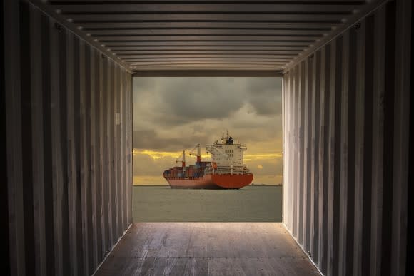 A container ship sailing away from the view of a container.