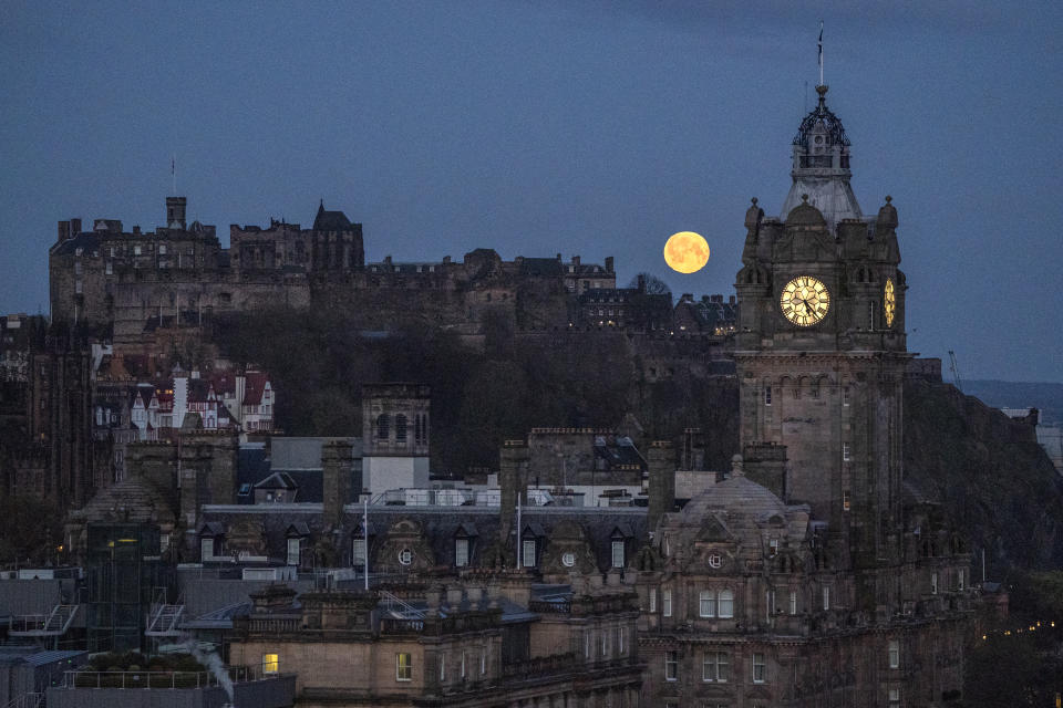 The full moon, which is known as the 'Pink Moon' during April, sets sets behind The Balmoral Clock and Edinburgh Castle. Picture date: Wednesday April 24, 2024. (Photo by Jane Barlow/PA Images via Getty Images)