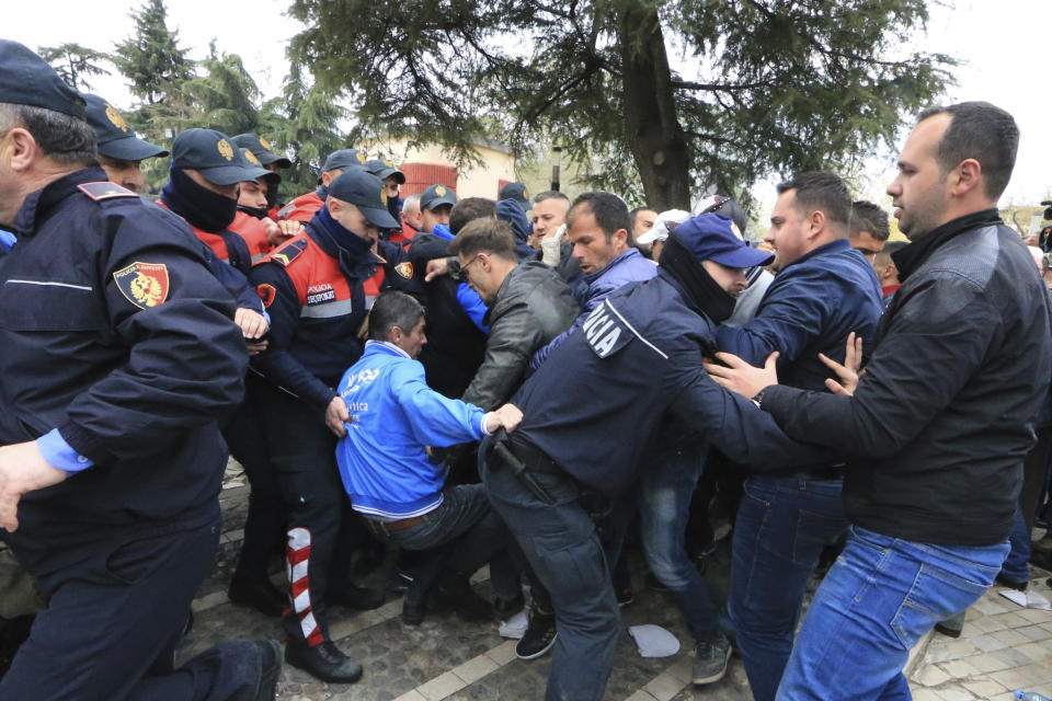 Protesters clash with police front of the Albanian parliament building in Tirana, on Thursday, March 28, 2019. Albanian opposition protesters have repeated attempts to enter the parliament by force in their protest asking for the government's resignation and an early election.(AP Photo/ Hektor Pustina)