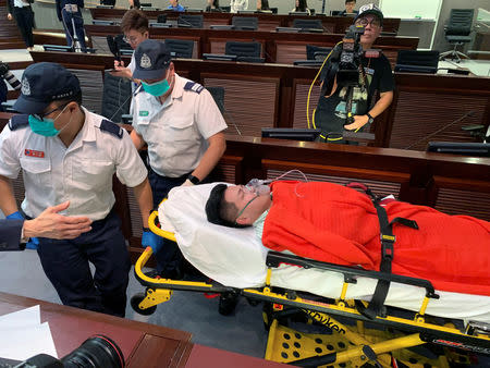 Pro-democracy lawmaker Gary Fan is carried on a stretcher carry away on a stretcher after clashes with pro-Beijing lawmakers during a meeting for control of a meeting room to consider the controversial extradition bill, in Hong Kong, China May 11, 2019. REUTERS/James Pomfret