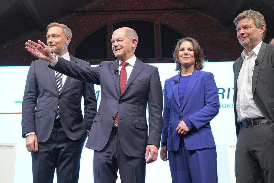 From left, Christian Lindner, party leader of the FDP, Olaf Scholz, SPD candidate for chancellor and executive federal minister of finance, Annalena Baerbock, federal leader of the Green party and Robert Habeck, federal leader of the Green party at a joint news conference in Berlin, Germany, Wednesday, Nov. 24, 2021. After weeks of negotiations the leaders of the three parties present a coalition contract for a new German government. (Kay Nietfeld/dpa via AP)