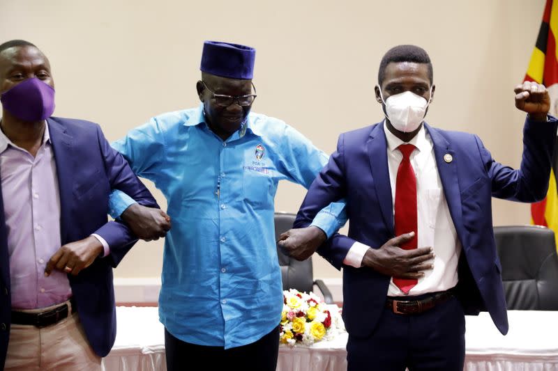 Ugandan opposition presidential candidate Robert Kyagulanyi, also known as Bobi Wine, poses with other opposition leaders Patrick Oboi Amuriat and Mugisha Muntu during a press conference in Kampala