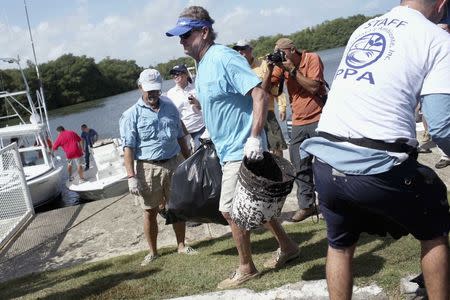 U.S. artist and conservationist Guy Harvey (C) leads a group of volunteers along the San Juan estuary system for the second "mega cleanup" of garbage from the waterway, in San Juan, in this October 26, 2013 file picture. REUTERS/Alvin Baez/Files