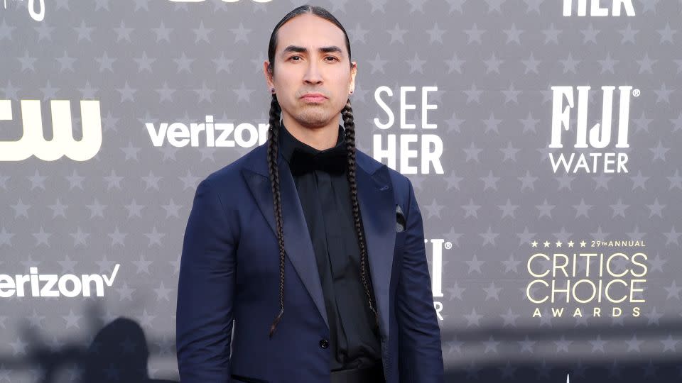 “Killers of the Flower Moon” star Tatanka Means looked suave in a navy and black suit. - Matt Winkelmeyer/Getty Images