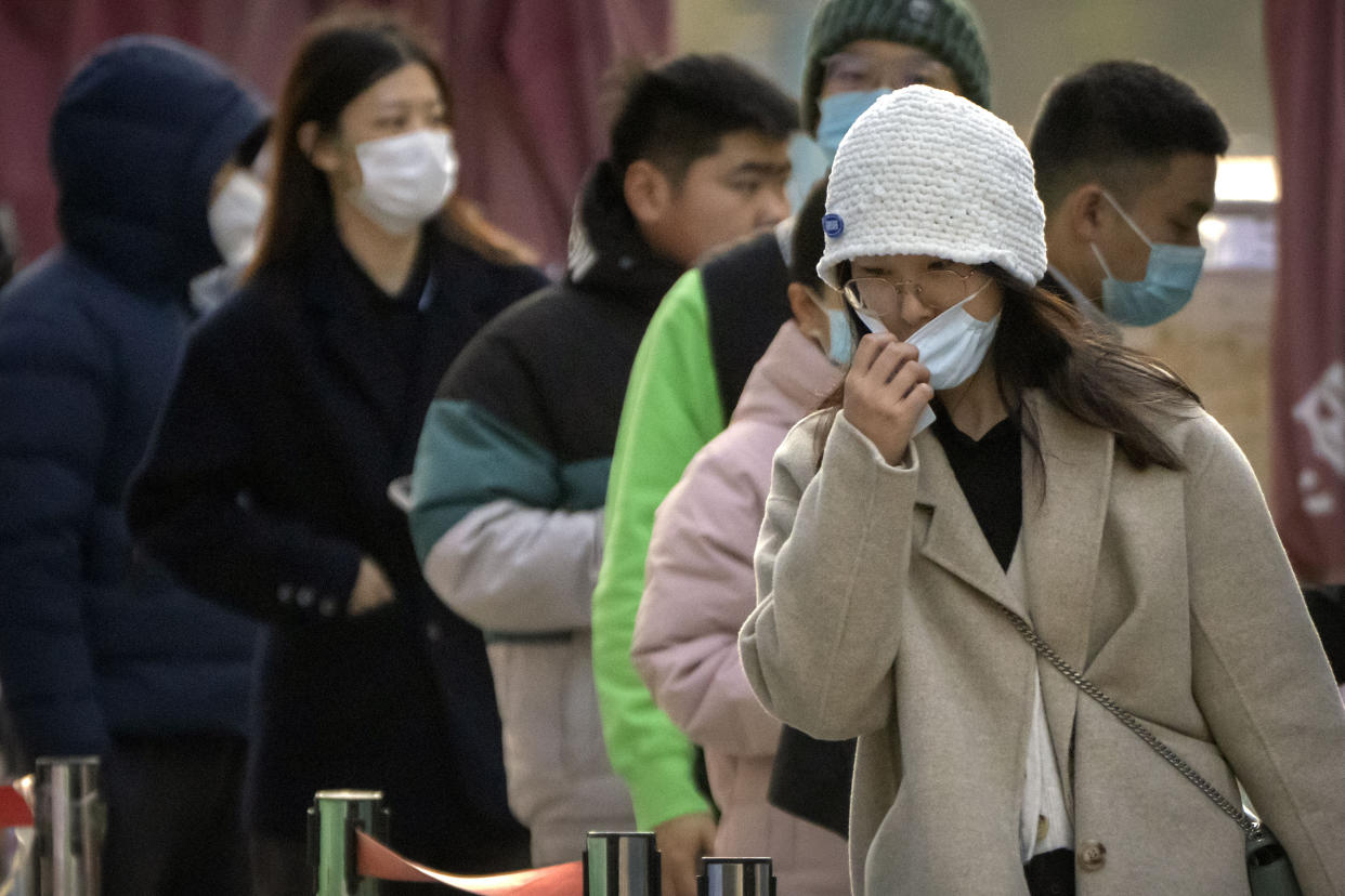 A woman adjusts her face mask after taking a COVID-19 test at a coronavirus testing site in Beijing, Thursday, Nov. 17, 2022. Chinese authorities faced more public anger Thursday after a second child's death was blamed on overzealous anti-virus enforcement, adding to frustration at controls that are confining millions of people to their homes and sparked fights with health workers. (AP Photo/Mark Schiefelbein)