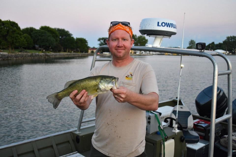 Fisheries Biologist Zak Slagle holds one of the fist collected in an electrofishing survey in Lake Erie. The electrofishing crew collects data for use by scientists, university students and fishermen.