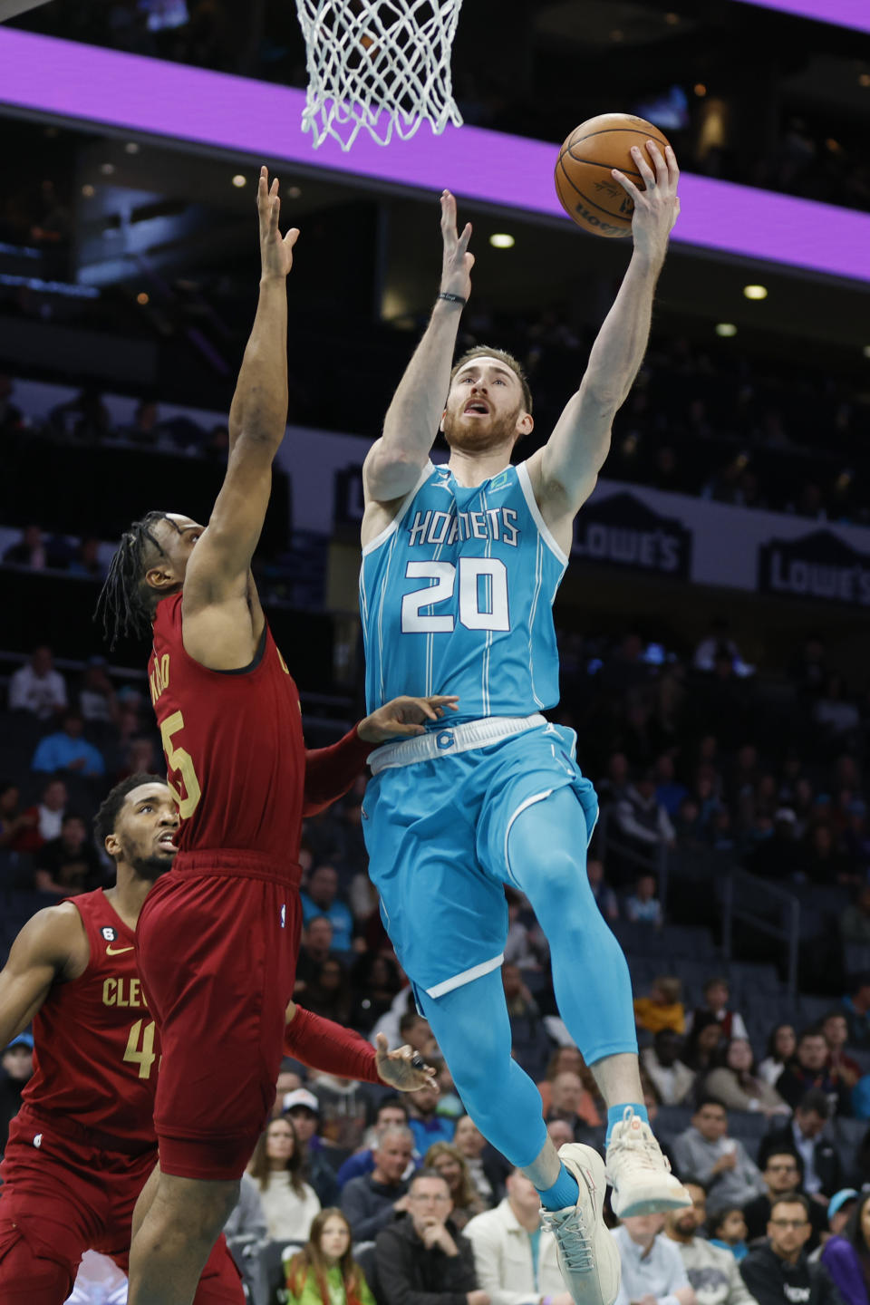 Charlotte Hornets forward Gordon Hayward (20) drives to the basket against Cleveland Cavaliers forward Isaac Okoro during the first half of an NBA basketball game in Charlotte, N.C., Sunday, March 12, 2023. (AP Photo/Nell Redmond)