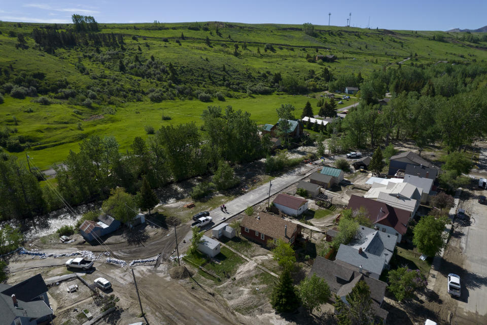 In this aerial image taken with a drone, sandbags and mud covered roads are left behind after floodwaters from Rock Creek receded, Wednesday, June 15, 2022, in Red Lodge, Mont. Historic floodwaters that raged through Yellowstone National Park may have permanently altered the course of a popular fishing river and left the sweeping landscape forever changed. (AP Photo/Brittany Peterson)