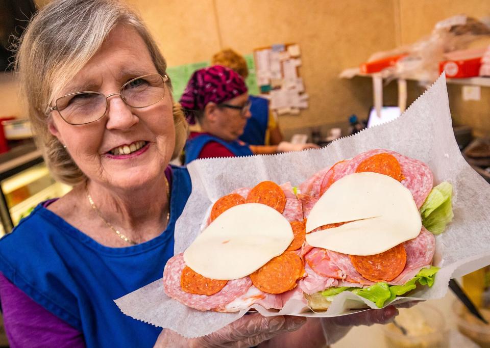 Employee Pam Sampson holds a Ma Barker's Sub at Southside Deli in Ocala.