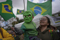 A supporter of Brazilian President Jair Bolsonaro holds her son who is dressed in a Hulk costume, during a protest against Bolsonaro's defeat in the country's presidential runoff, outside a military base in Sao Paulo, Brazil, Thursday, Nov. 3, 2022. Some supporters are calling on the military to keep Bolsonaro in power, even as his administration signaled a willingness to hand over the reins to his rival, President-elect Luiz Inacio Lula da Silva. (AP Photo/Matias Delacroix)