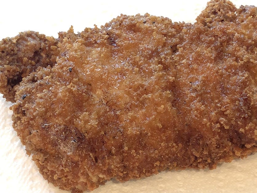 fried pork chop sitting on paper towel