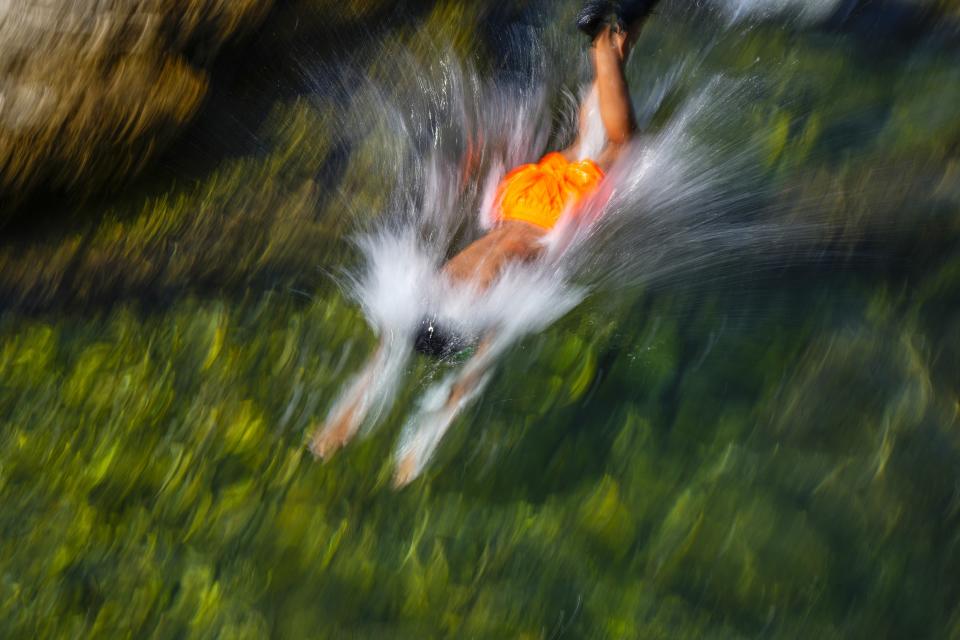 A young man jumps in the water to cool off on a sweltering day in the Mediterranean Sea in Beirut, Lebanon, Thursday, July 20, 2023. (AP Photo/Hassan Ammar)