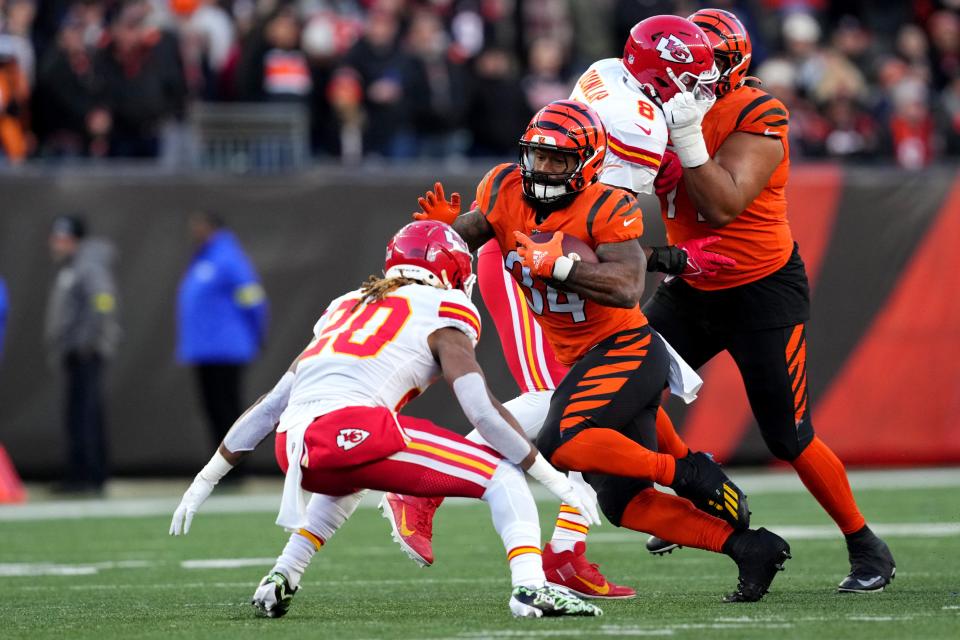 Cincinnati Bengals running back Samaje Perine carries the ball as Kansas City Chiefs safety Justin Reid approaches.