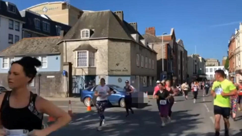 The car pulls out in front of runners (Picture: SWNS)
