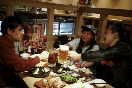 Professional wrestler Kris Wolf (C) meets fans Eiichi Nakazato (R) and Eishi Matsumoto in a restaurant in Tokyo, Japan, March 12, 2016. REUTERS/Thomas Peter