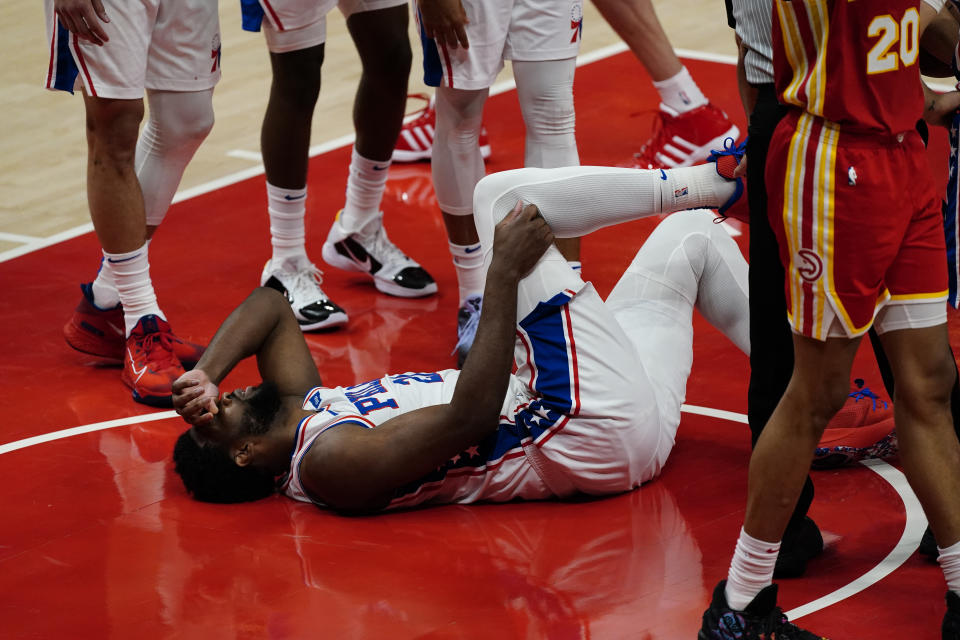 Philadelphia 76ers center Joel Embiid (21) lies on the court before returning to play during the second half of Game 3 of a second-round NBA basketball playoff series against the Atlanta Hawks, Friday, June 11, 2021, in Atlanta. (AP Photo/John Bazemore)