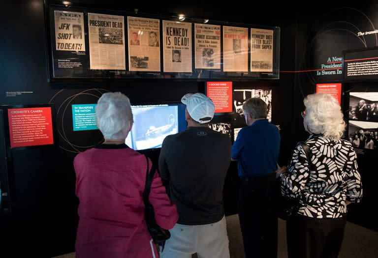 (FILES) In this file photo taken on September 26, 2013, people view an exhibit about the 1963  assassination of former US president John F. Kennedy at the Newseum in Washington, DC. - The US National Archives released on December 15, 2022 a new trove of files related to the November 1963 assassination of president John F. Kennedy. A total of 12,879 documents were made public, the archives said, but thousands more were blocked from release by the White House, citing national security concerns. (Photo by BRENDAN SMIALOWSKI / AFP)
