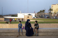 A family wears face mask to prevent the spread of coronavirus while enjoying their evening by the cornice, in Rabat, Morocco, Tuesday, Sept. 22, 2020. (AP Photo/Mosa'ab Elshamy)