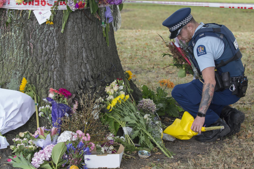 Police move floral tributes near the Al Noor Mosque on Deans Rd in Christchurch. Source: AAP