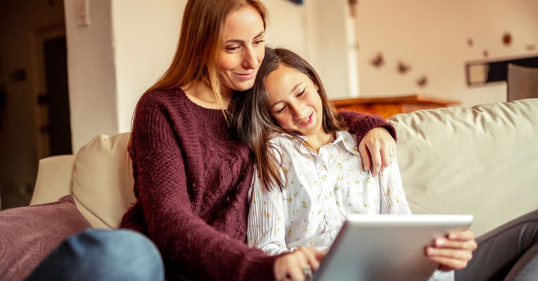 mother and daughter spending time together using digital tablet