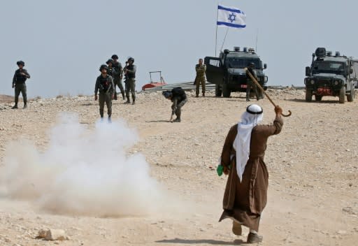 A Palestinian protester raises his walking cane as he stands before Israeli border guards during a demonstration against Israeli settlers pitching tents in an area of the village of al-Sawahre in East Jerusalem in September 2019