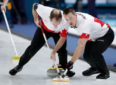 Curling - Pyeongchang 2018 Winter Olympics - Men's Bronze Medal Match - Switzerland v Canada - Gangneung Curling Center - Gangneung, South Korea - February 23, 2018 - Second Brent Laing of Canada and lead Ben Hebert of Canada sweep. REUTERS/John Sibley