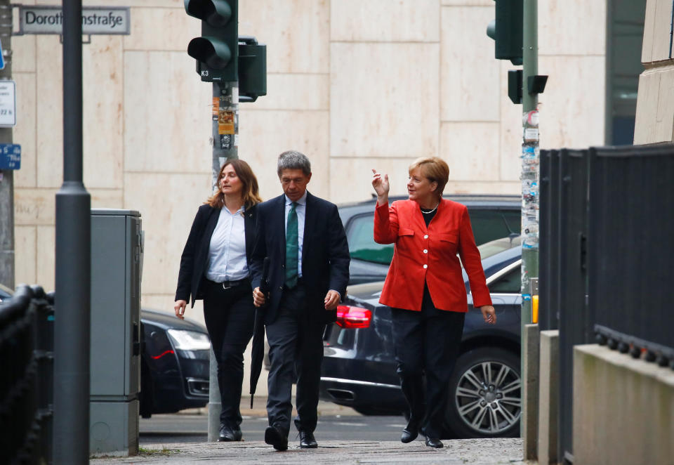 Die Bundeskanzlerin weist ihren Mann auf das schlechte Wetter hin. (Bild: Reuters)