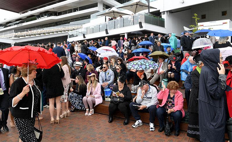 <p>Pictured: Punters brave wild weather as Melbourne Cup festivities get underway</p>