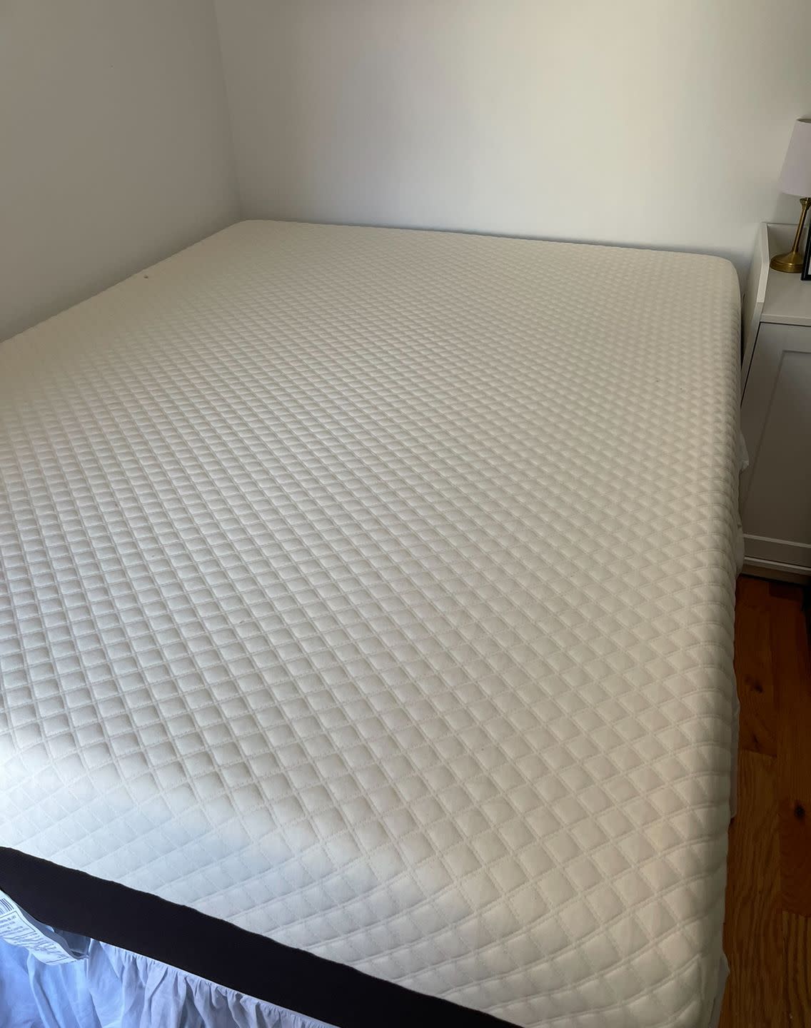 a bare mattress on a bed frame