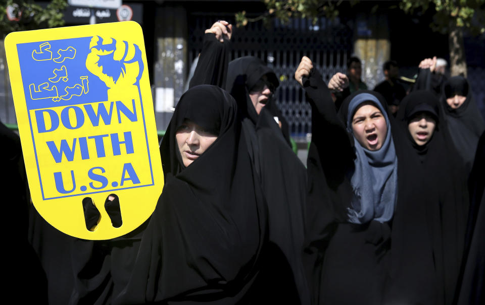 Worshippers chant slogans against America, Israel and Saudi Arabia, as one of them holds up an anti-American placard, in a rally to condemn Saturday's terror attack in Ahvaz, after Friday prayers in Tehran, Iran, Friday, Sept. 28, 2018. On Saturday, armed men disguised as soldiers killed 24 and wounded 60 people in an attack targeting a military parade in Ahvaz, southern Iran. (AP Photo/Ebrahim Noroozi)