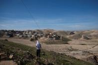 A Jewish shepherd wears a prayer shawl as he stands near houses in the Israeli settlement of Mitzpe Yericho in the Jordan Valley in the Israeli-occupied West Bank