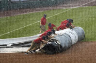 Grounds crew members unroll the tarp to cover the baseball diamond from a heavy downpour delaying a baseball game during the sixth inning between the Washington Nationals and the Baltimore Orioles in Washington, Sunday, Aug. 9, 2020. (AP Photo/Manuel Balce Ceneta)