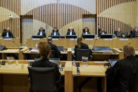 Presiding judge Hendrik Steenhuis, rear, fourth from left, opens the court session as the trial resumed at the high security court building at Schiphol Airport, near Amsterdam, Monday, June 8, 2020, for three Russians and a Ukrainian charged with crimes including murder for their alleged roles in the shooting down of Malaysia Airlines Flight MH17 over eastern Ukraine nearly six years ago. (AP Photo/Robin van Lonkhuijsen, POOL)