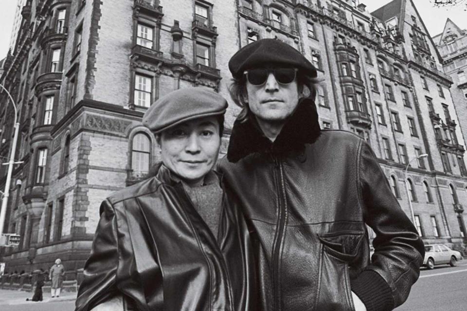 <p>Allan Tannenbaum/Polaris</p> John Lennon and Yoko Ono pose in front of the Dakota in 1980