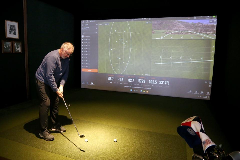 Rick Stanton takes a swing at a golf simulator at the Coach Club in North Hampton on Tuesday, Dec. 6, 2022.