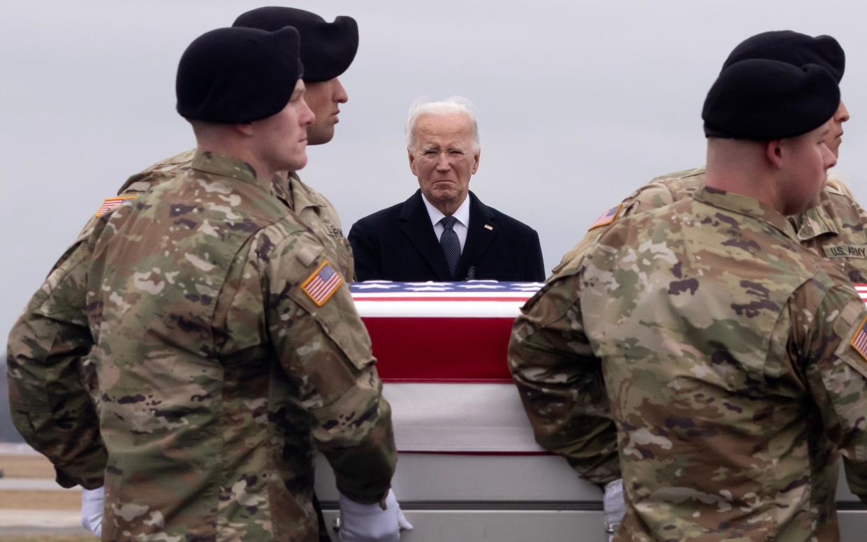 Joe Biden watches a US Army team carrying the remains of a soldier who died in the recent Jordan drone strike