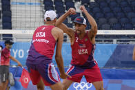 Nicholas Lucena, center, of the United States, celebrates with teammate Philip Dalhausser during a men's beach volleyball match at the 2020 Summer Olympics, Tuesday, July 27, 2021, in Tokyo, Japan. (AP Photo/Petros Giannakouris)