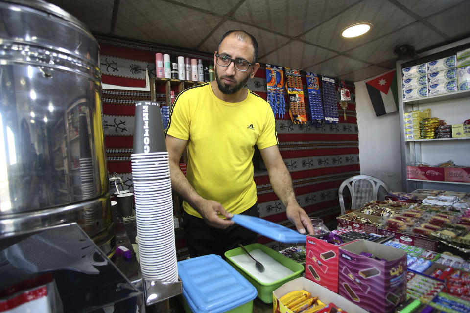 In this photo taken Wednesday, June 7, 2023, 2023, Bilal Mahmoud, a 32-year-old engineering graduate, works a ta coffee stand in Al Qatraneh, some 95 kilometers (59 miles) south of Jordan's capital, Amman (AP Photo/Raad Adayleh)