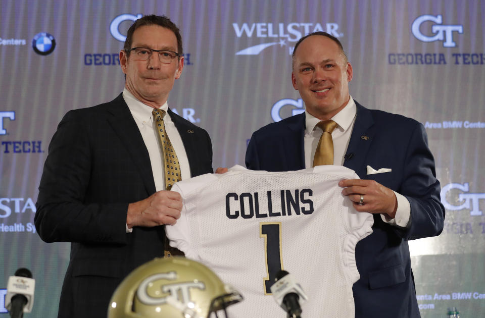 Newly hired Georgia Tech football coach Geoff Collins, right, and athletic director Todd Standsbury pose with a school jersey during a news conference Friday, Dec. 7, 2018, in Atlanta. (AP Photo/John Bazemore)