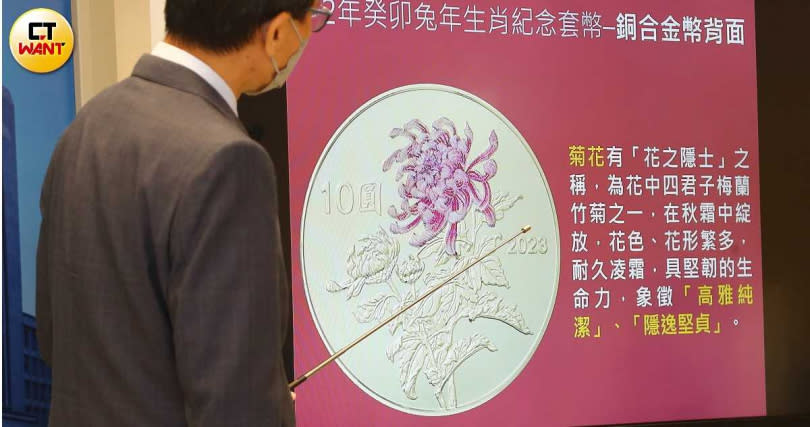 「癸卯兔年生肖紀念套幣」銅合金幣背面為部分上彩的「菊花」，面額10元。（圖／黃鵬杰攝）
