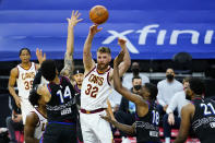 Cleveland Cavaliers' Dean Wade (32) passes the ball between Philadelphia 76ers' Shake Milton (18) and Danny Green (14) during the first half of an NBA basketball game, Saturday, Feb. 27, 2021, in Philadelphia. (AP Photo/Matt Slocum)