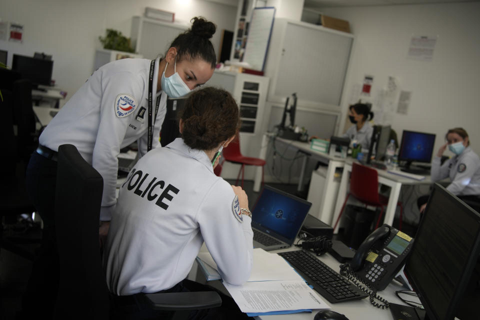 French female police officers work in a police station in Paris, Tuesday, Nov. 23, 2021. French Junior Interior Minister Marlene Schiappa said France must further help women victims of violence to report abuses to the police, including via a new process to file a complaint at a friend’s home or in a place where they feel safe. (AP Photo/Christophe Ena)
