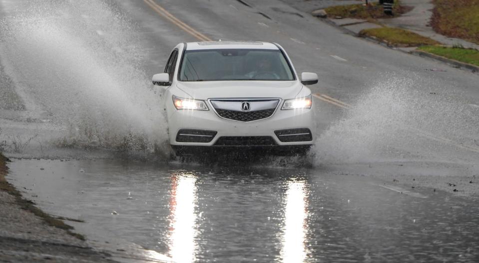 A car drives through standing water on Upper Wetumpka Road in Montgomery on Tuesday after overnight thunderstorms.