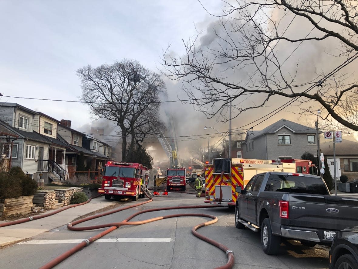 Firefighters rescued 11 people from an active four-alarm blaze near Leeds Street and Ossington Avenue. Toronto Fire says four people had to be taken to the hospital, with one person in life-threatening condition. (Robert Krbavac/CBC News - image credit)