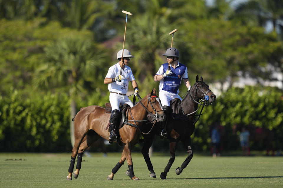 Britain's Prince Harry, right, talks with Louis Devaleix as they ride out for the start of the 2024 Royal Salute Polo Challenge to Benefit Sentebale, Friday, April 12, 2024, in Wellington, Fla. Prince Harry, co-founding patron of the Sentebale charity, will play on the Royal Salute Sentebale Team. (AP Photo/Rebecca Blackwell)